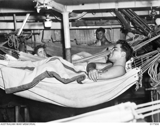 Část posádky HMAS Nepál v houpacích sítích, když se loď blíží australskému přístavu – 29. srpna 1944.  Australian War Memorial Archive